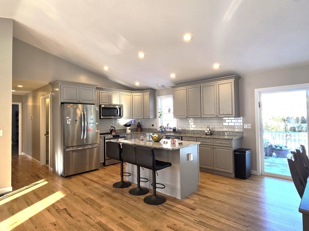 83 Comins Pond Road Warren, MA 01083 - Photo 5 of 29 a kitchen with stainless steel appliances granite countertop a refrigerator oven stove a sink and a island with wooden floor