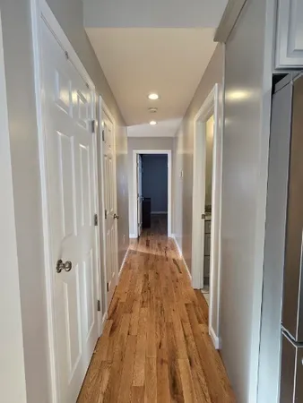 a view of a hallway with wooden floor and closet area