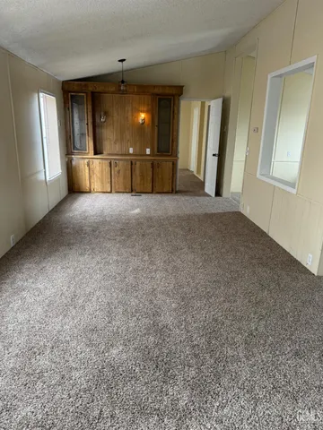 a view of a livingroom with an empty space and a window