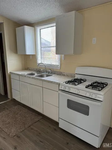 a kitchen with a stove a sink and a window