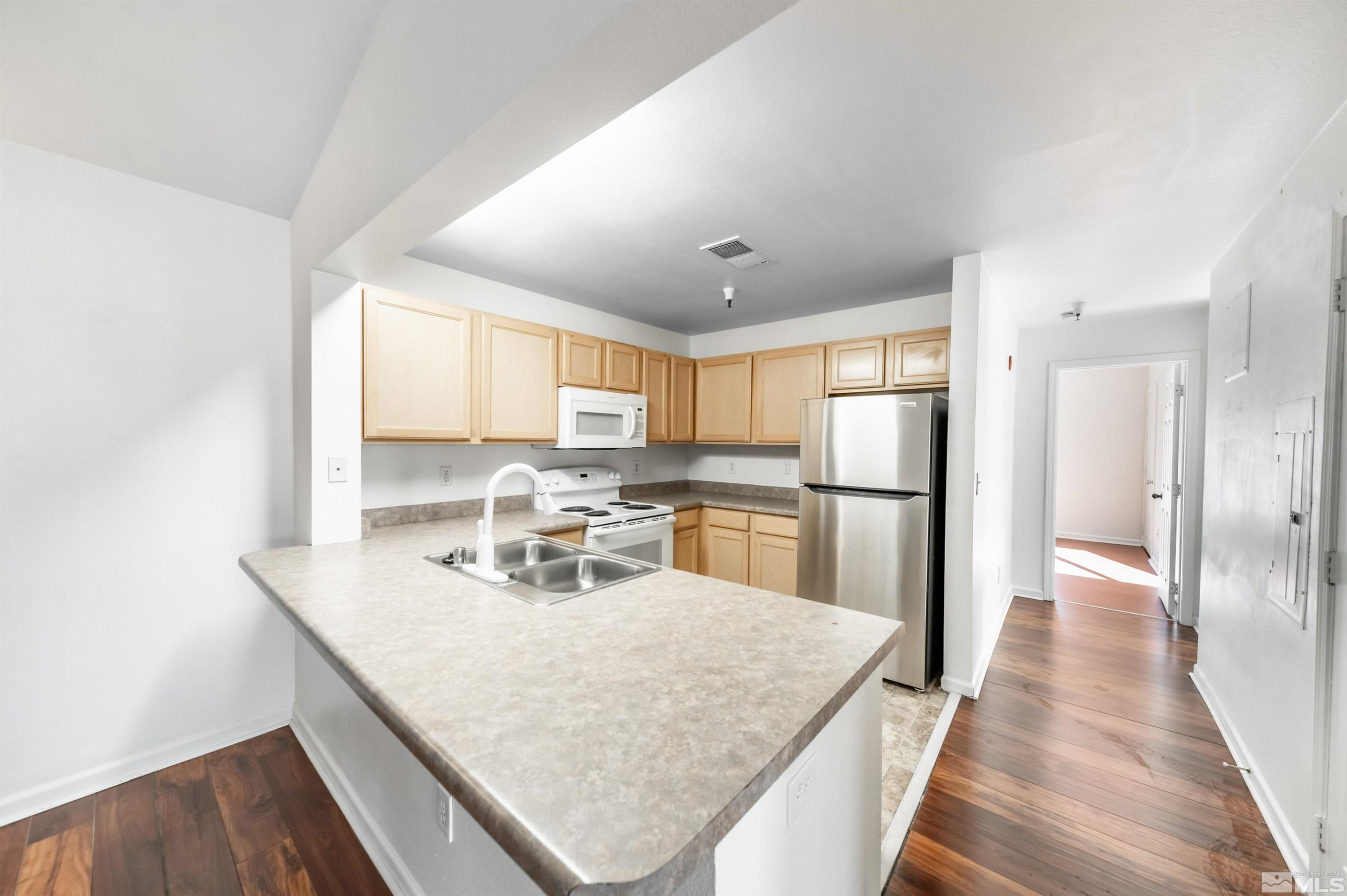 a kitchen with stainless steel appliances granite countertop sink refrigerator and microwave