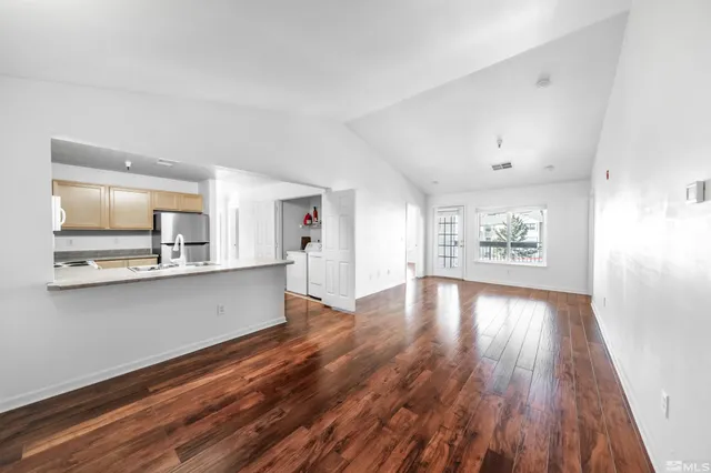 a view of a kitchen with wooden floor and a refrigerator