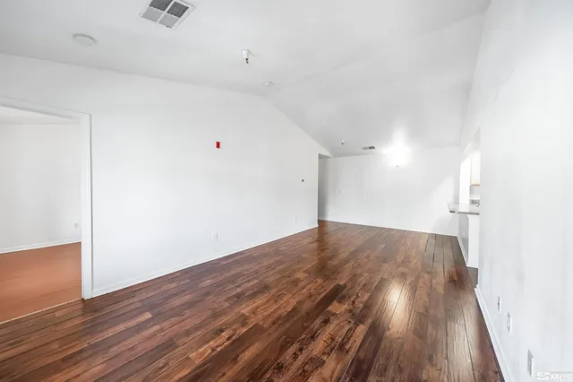a view of empty room with wooden floor