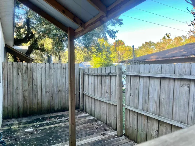 a view of a backyard with wooden fence and trees