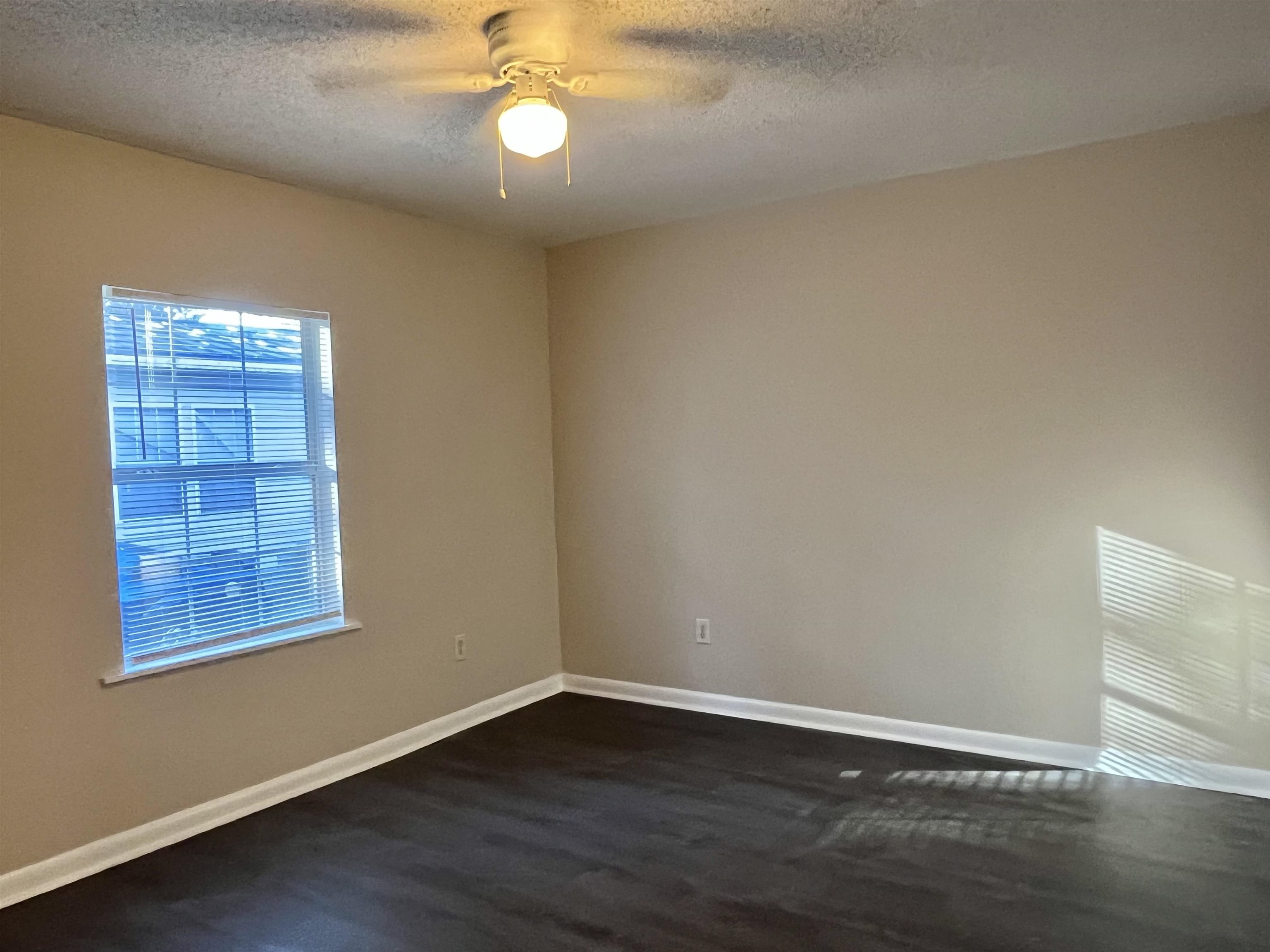 33 Evergreen Avenue, Unit B St. Augustine, FL 32084 - Photo 10 of 13 an empty room with wooden floor and windows