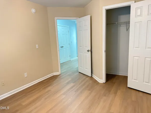 an empty room with wooden floor and closet