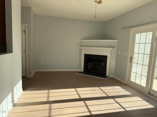 a view of an empty room with exposed radiator and fireplace