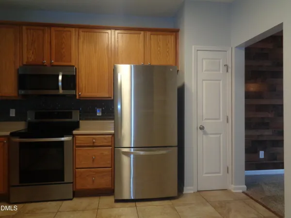 a metallic refrigerator freezer sitting in a kitchen