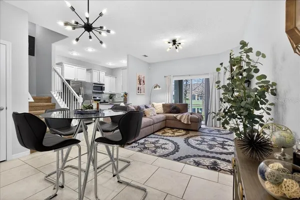 a living room with furniture flowers and a chandelier