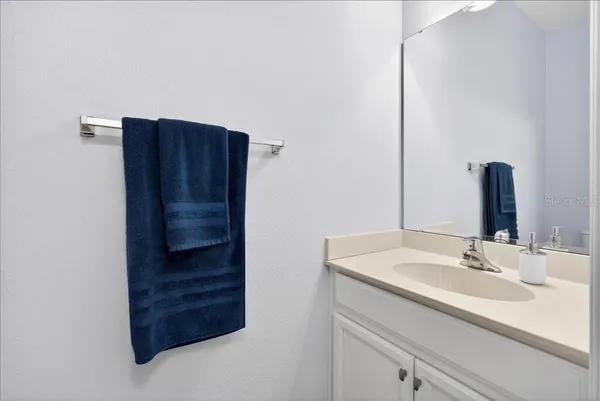 a bathroom with a sink vanity and a mirror