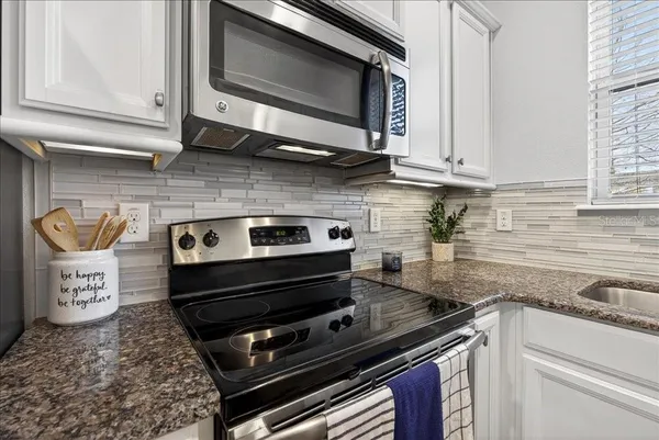 a kitchen with stainless steel appliances granite countertop a stove and a microwave