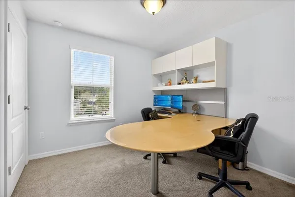 a view of a workspace with furniture and a window