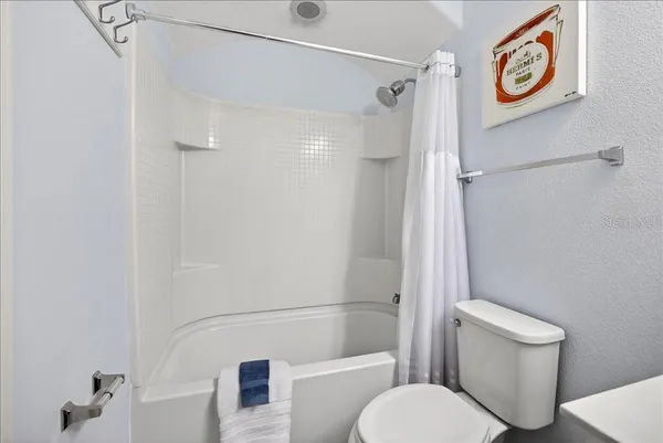 a white toilet sitting next to a bath tub