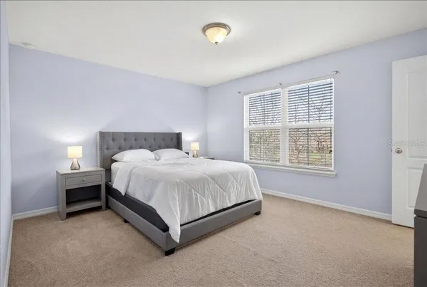 a bed sitting in a bedroom next to a window