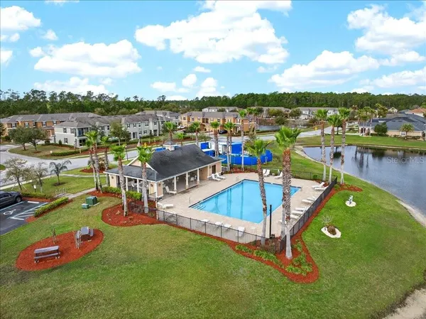 an aerial view of a house with a swimming pool and lake view