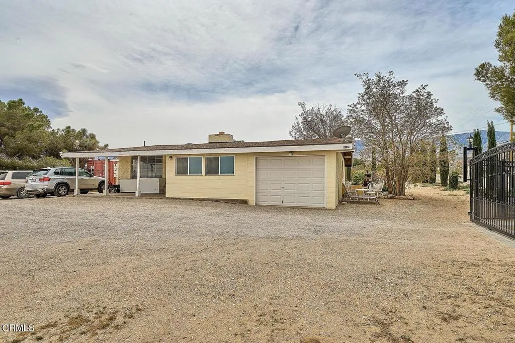9125 Mesa Road Lucerne Valley, CA 92356 - Photo 36 of 55 a view of a house with a parking space and a car parked in it