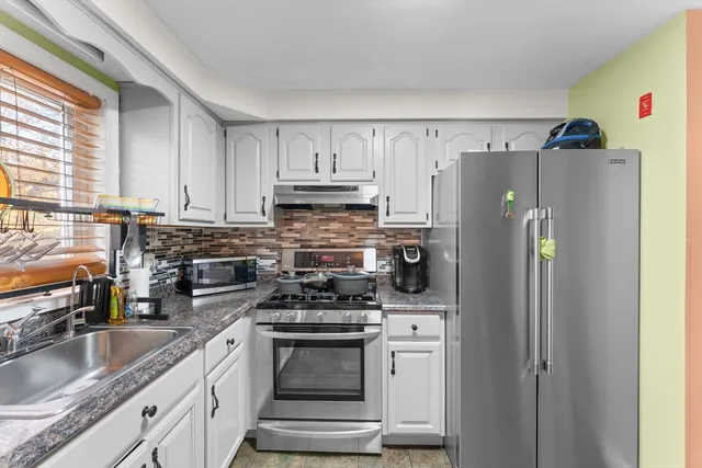 a kitchen with stainless steel appliances a refrigerator stove and sink