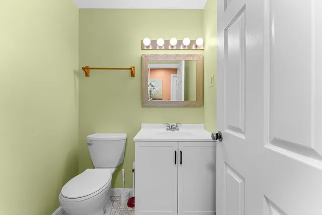 a bathroom with a toilet a sink and mirror