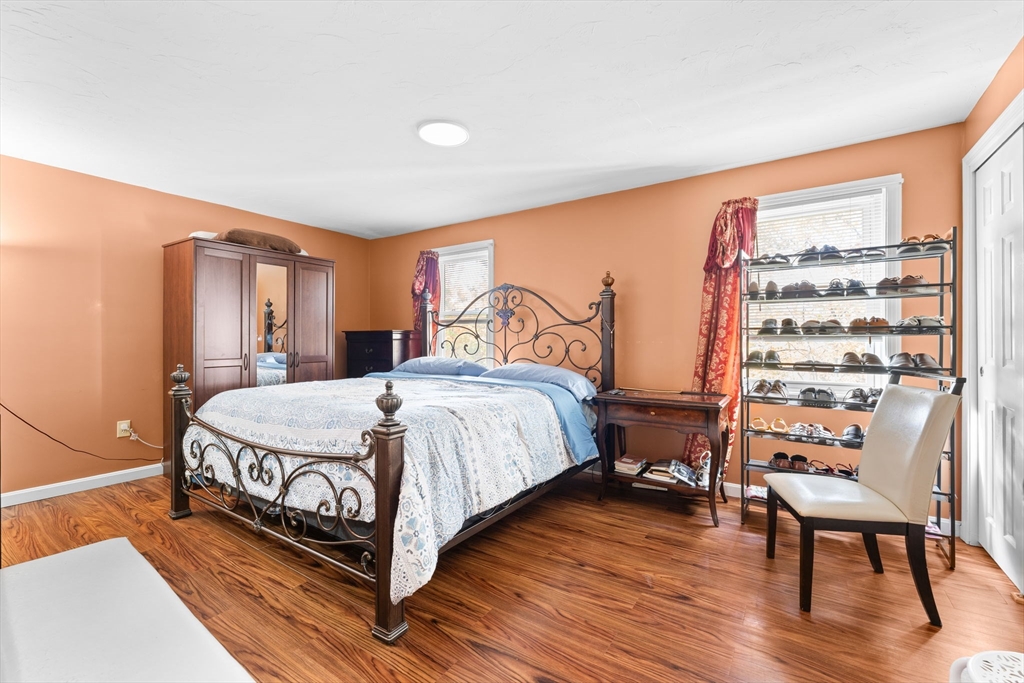 902 Irving Road, Unit 902 Randolph, MA 02368 - Photo 15 of 22 a bedroom with a bed and wooden floor