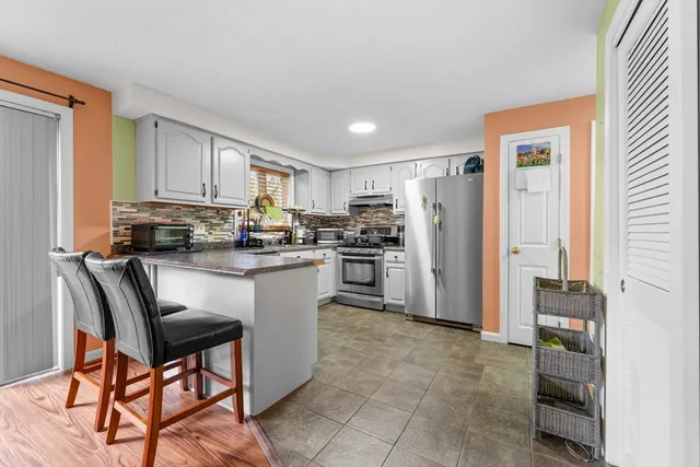 a kitchen with granite countertop a refrigerator stove top oven and sink