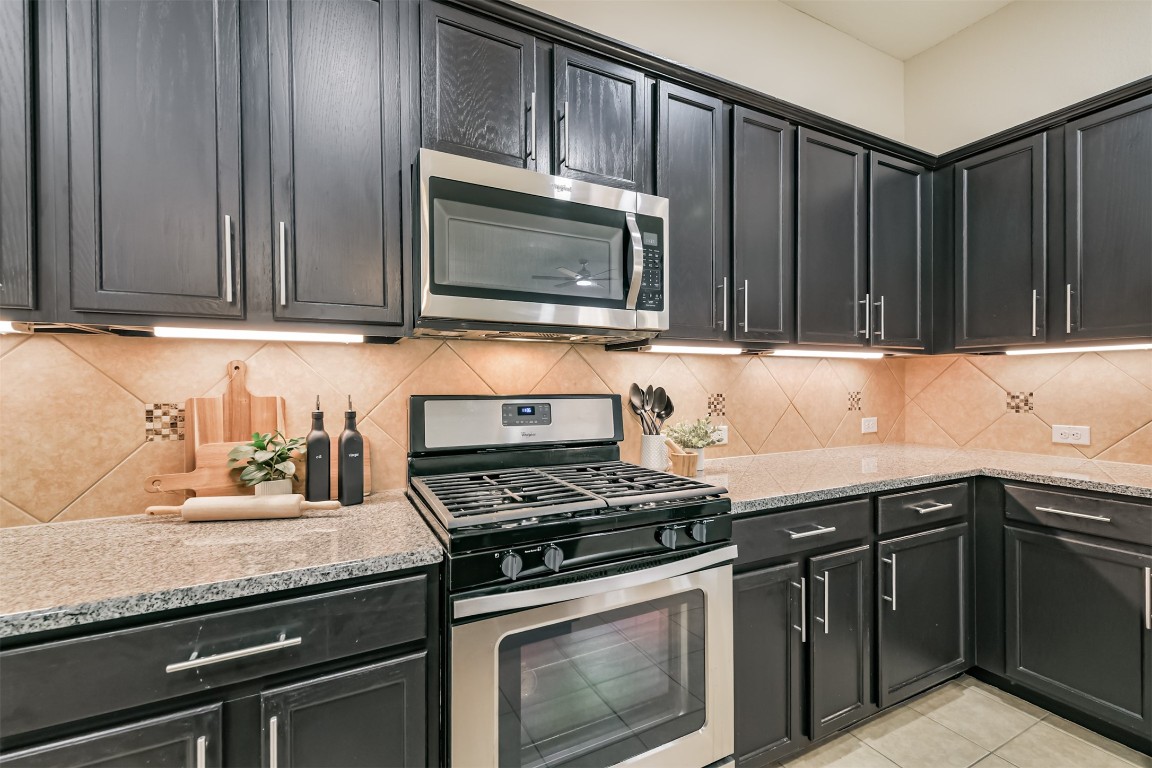 9622 Invergarry Way Tomball, TX 77375 - Photo 11 of 32 a kitchen with granite countertop a stove and a sink