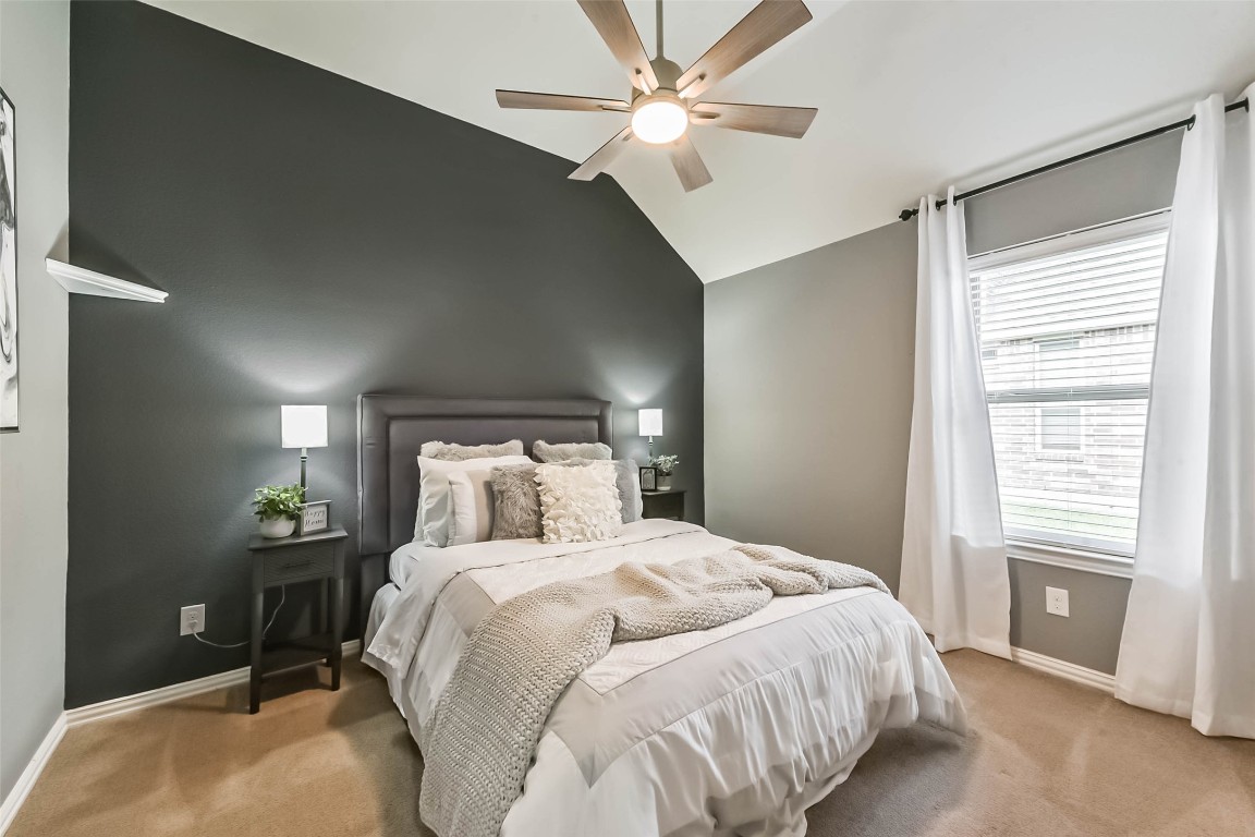 9622 Invergarry Way Tomball, TX 77375 - Photo 23 of 32 a bedroom with a large bed and a chandelier