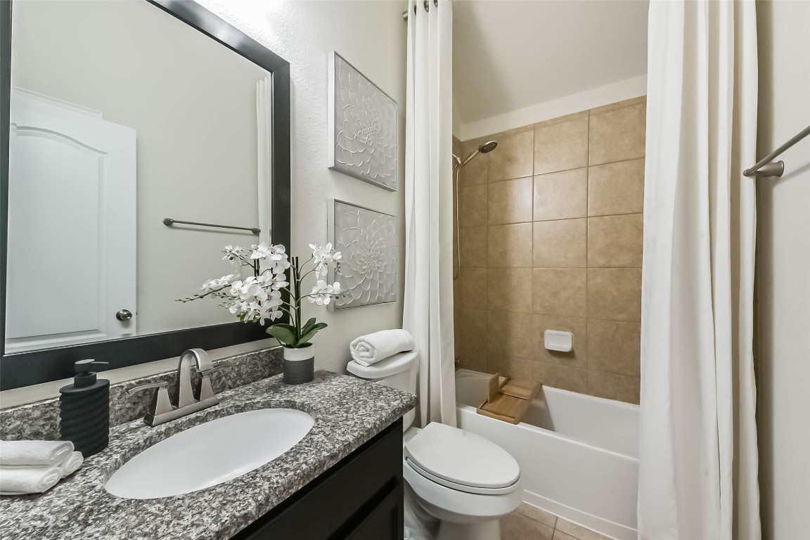 9622 Invergarry Way Tomball, TX 77375 - Photo 25 of 32 a bathroom with a granite countertop double vanity sink toilet mirror and shower