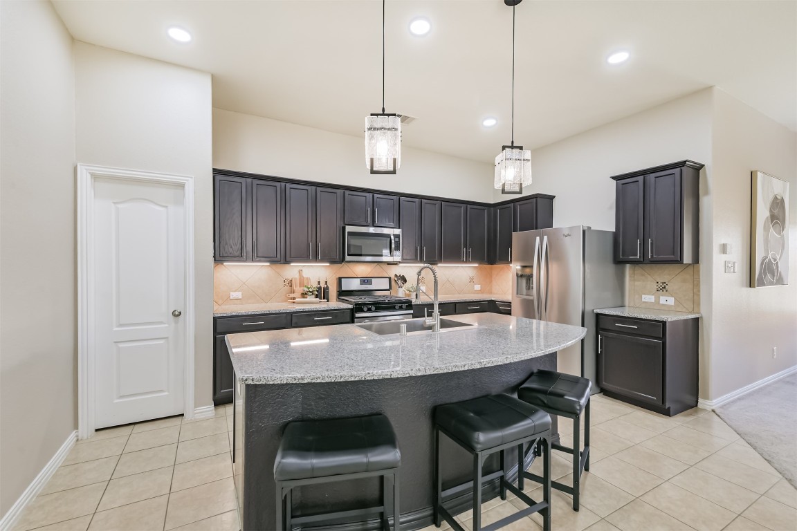 9622 Invergarry Way Tomball, TX 77375 - Photo 8 of 32 a kitchen with granite countertop a table chairs stainless steel appliances and cabinets