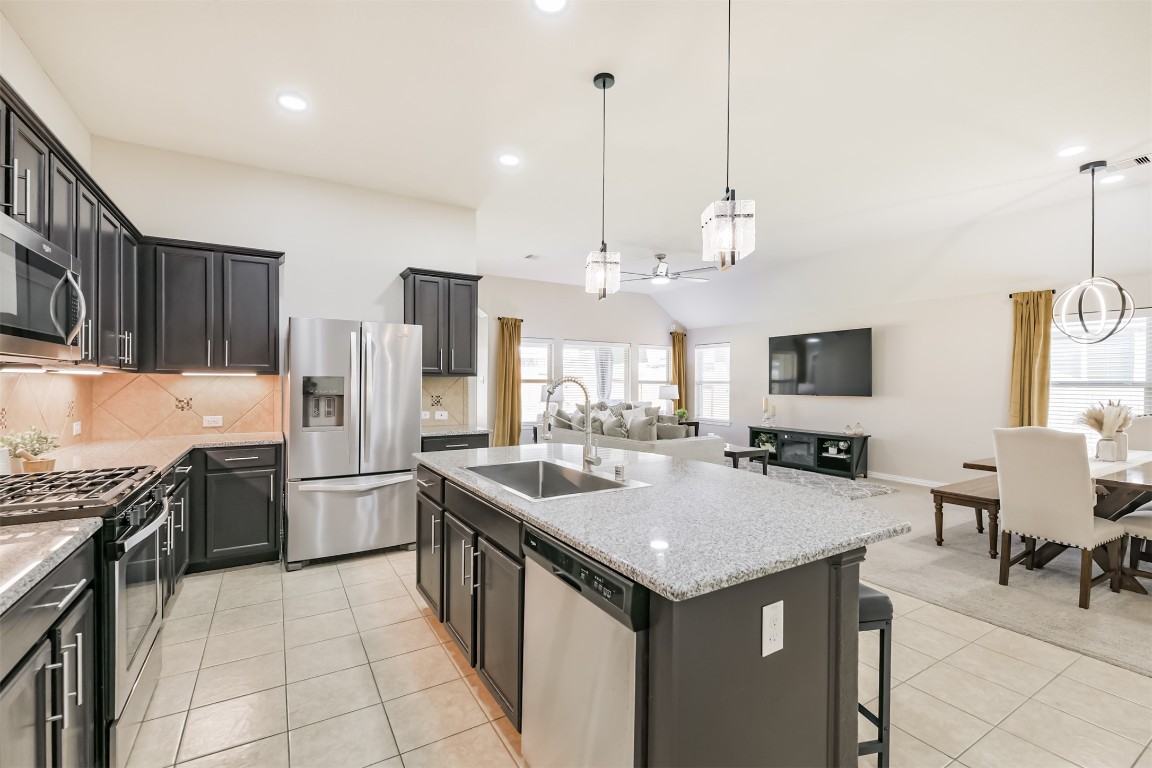 9622 Invergarry Way Tomball, TX 77375 - Photo 10 of 32 a kitchen with stainless steel appliances granite countertop a sink a stove and a refrigerator
