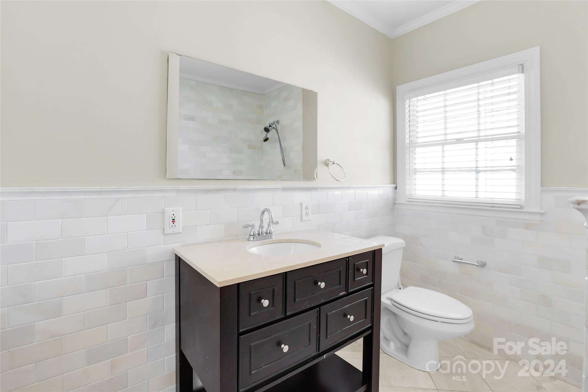 1408 Sterling Road Charlotte, NC 28209 - Photo 15 of 28 a bathroom with a toilet a sink a vanity and mirror