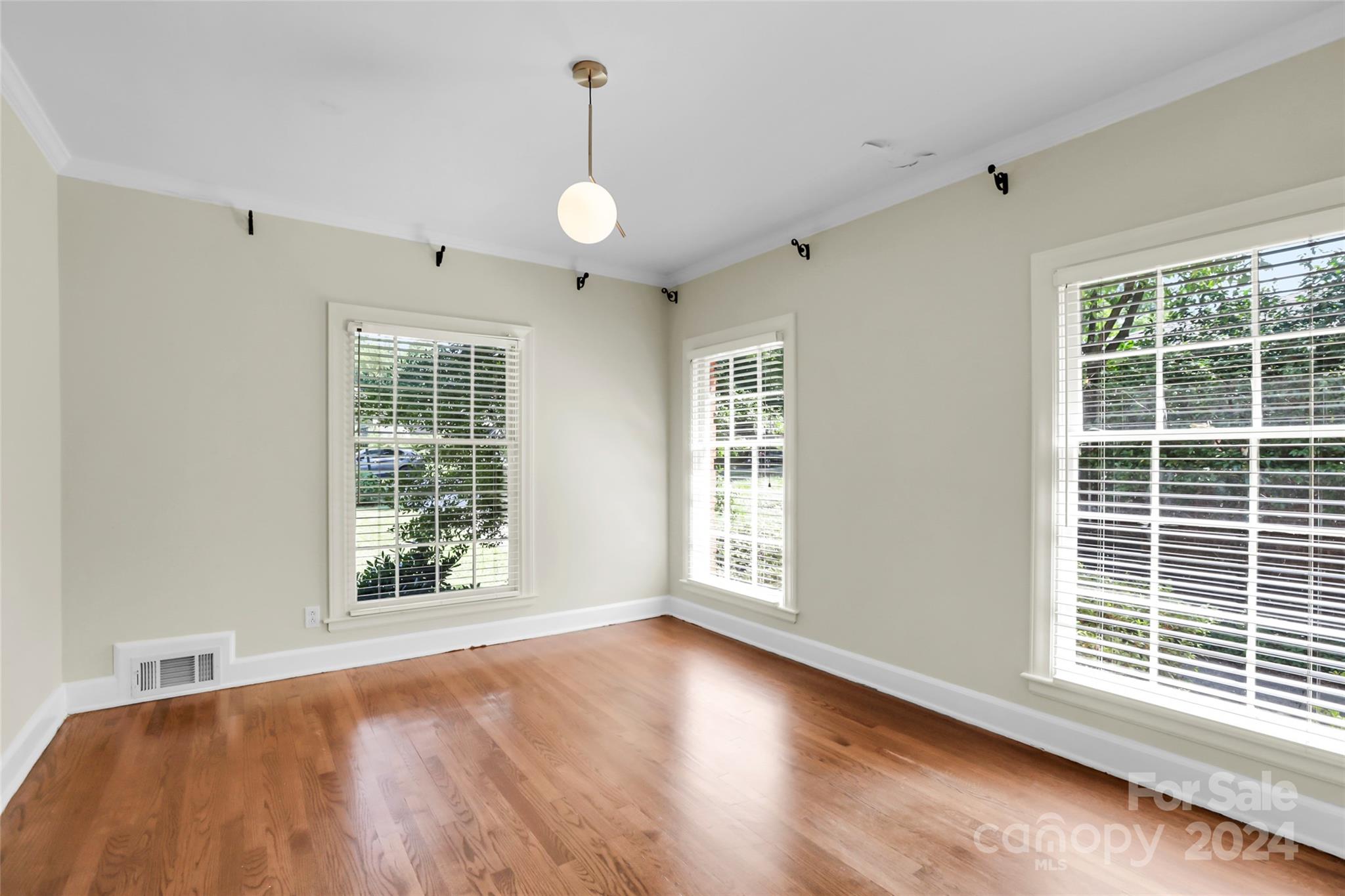 1408 Sterling Road Charlotte, NC 28209 - Photo 8 of 28 a view of an empty room with wooden floor and a window