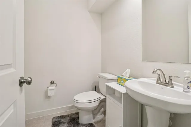 a bathroom with a sink a toilet and mirror