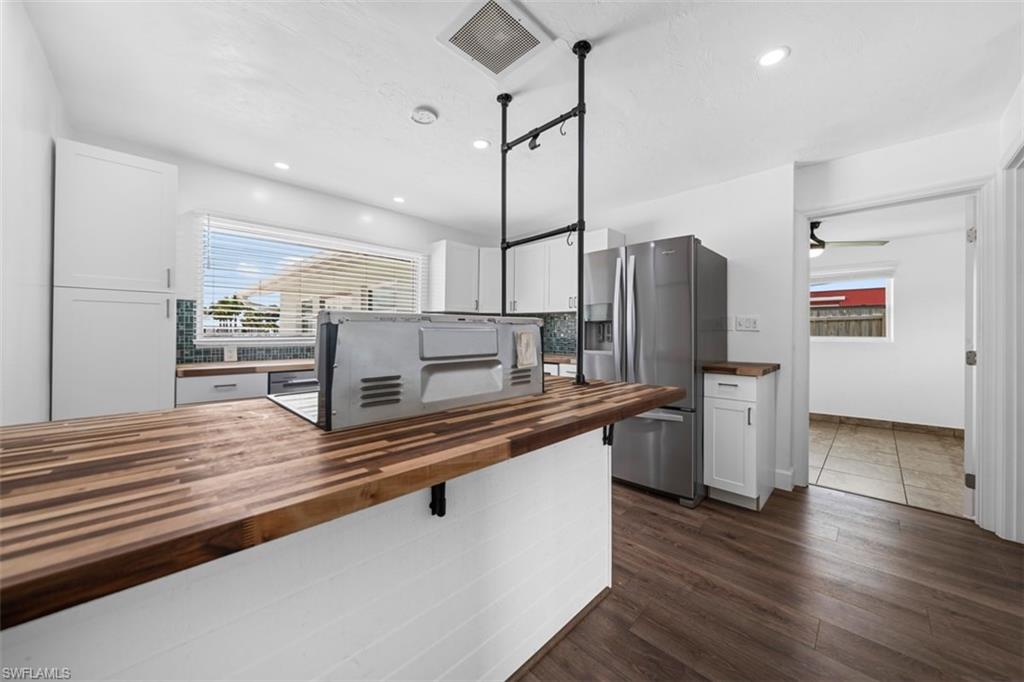 5460 Bayshore Road North Fort Myers, FL 33917 - Photo 8 of 14 a kitchen with stainless steel appliances a refrigerator and wooden floor