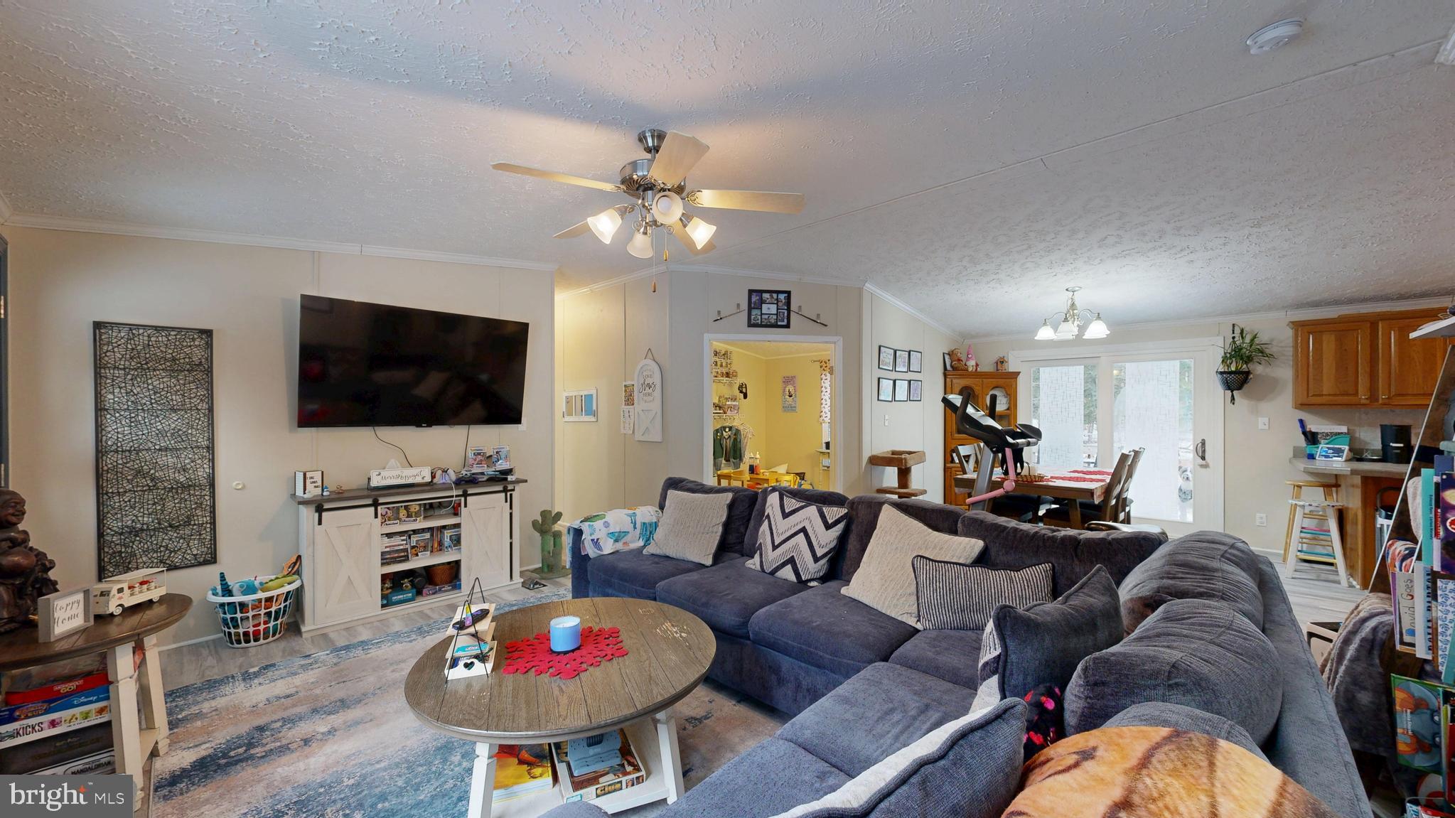22901 Camp Arrowhead Road Lewes, DE 19958 - Photo 19 of 39 a living room with furniture a flat screen tv and kitchen view