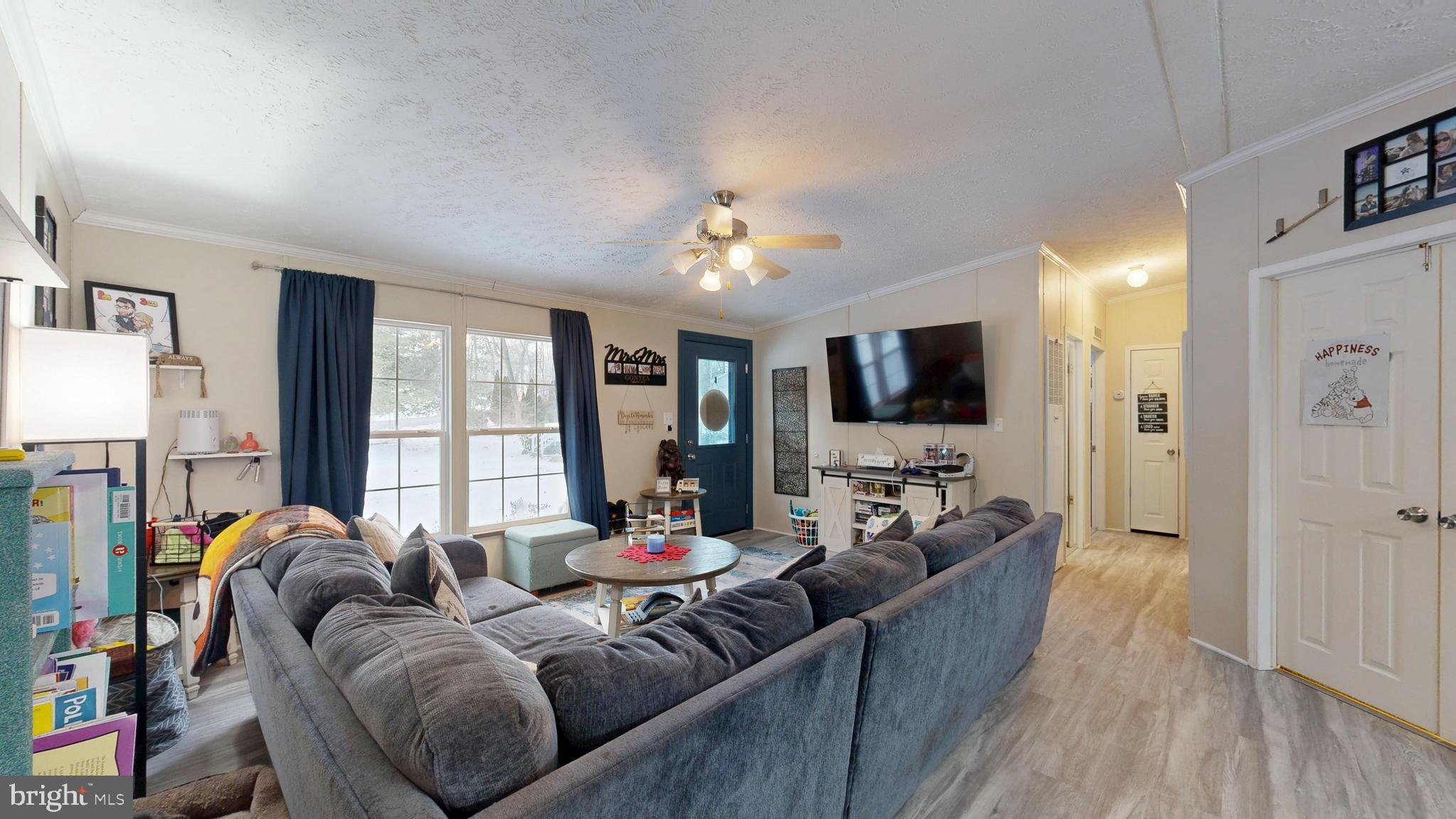 22901 Camp Arrowhead Road Lewes, DE 19958 - Photo 20 of 39 a living room with furniture a flat screen tv and a large window