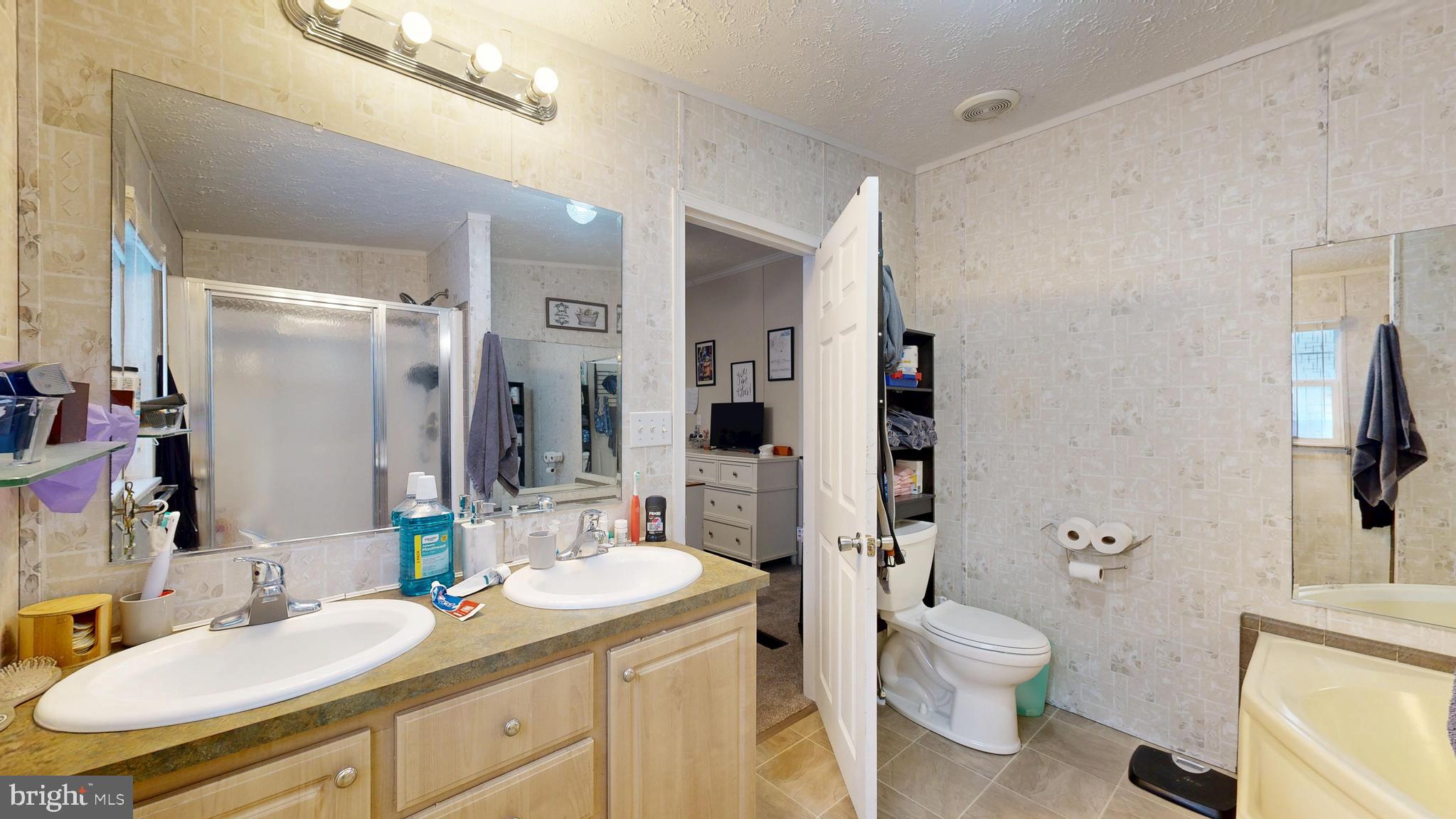 22901 Camp Arrowhead Road Lewes, DE 19958 - Photo 34 of 39 a bathroom with a granite countertop sink toilet and shower