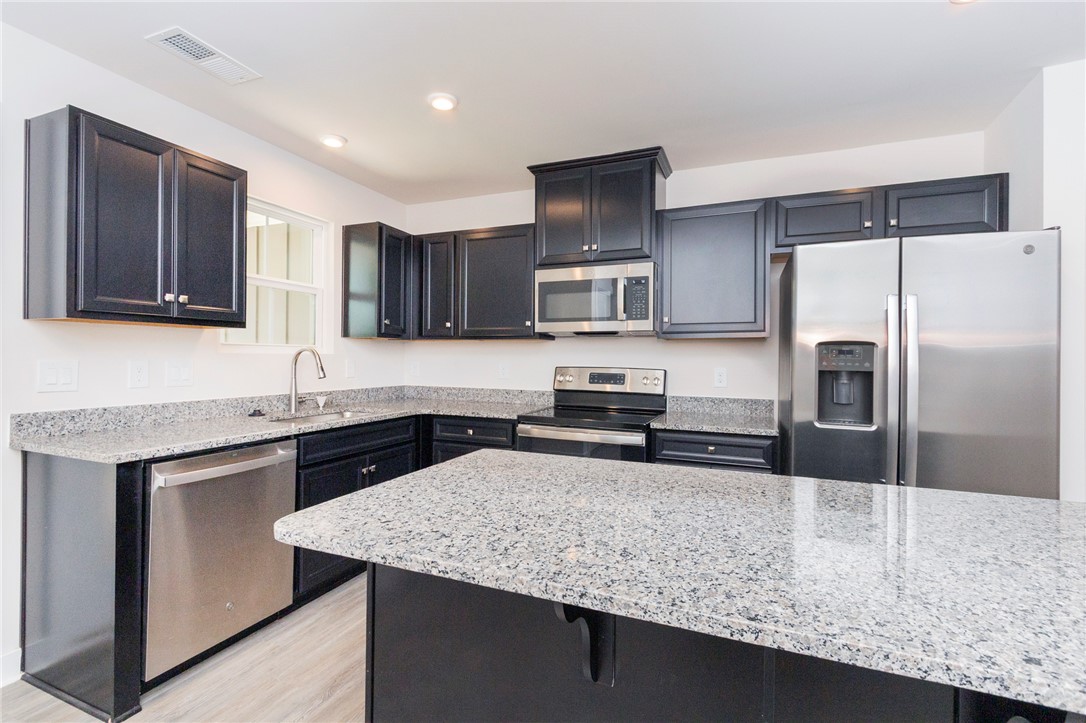 233 Scenic Road Anderson, SC 29621 - Photo 14 of 50 Modern kitchen with granite countertops and stainless steel appliances awaits culinary adventures.