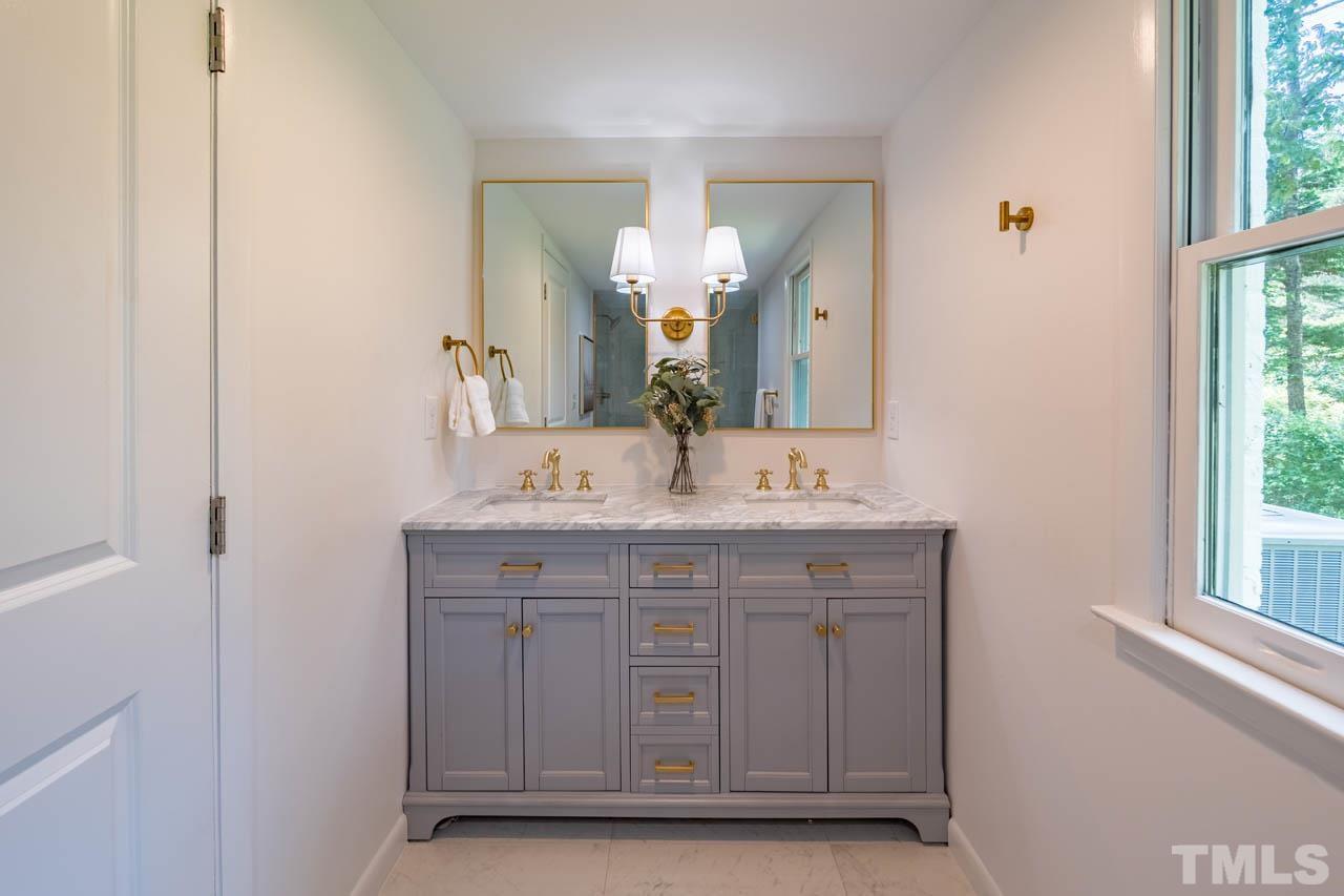2823 Ridge Road Durham, NC 27705 - Photo 16 of 30 a bathroom with a double vanity sink and a mirror