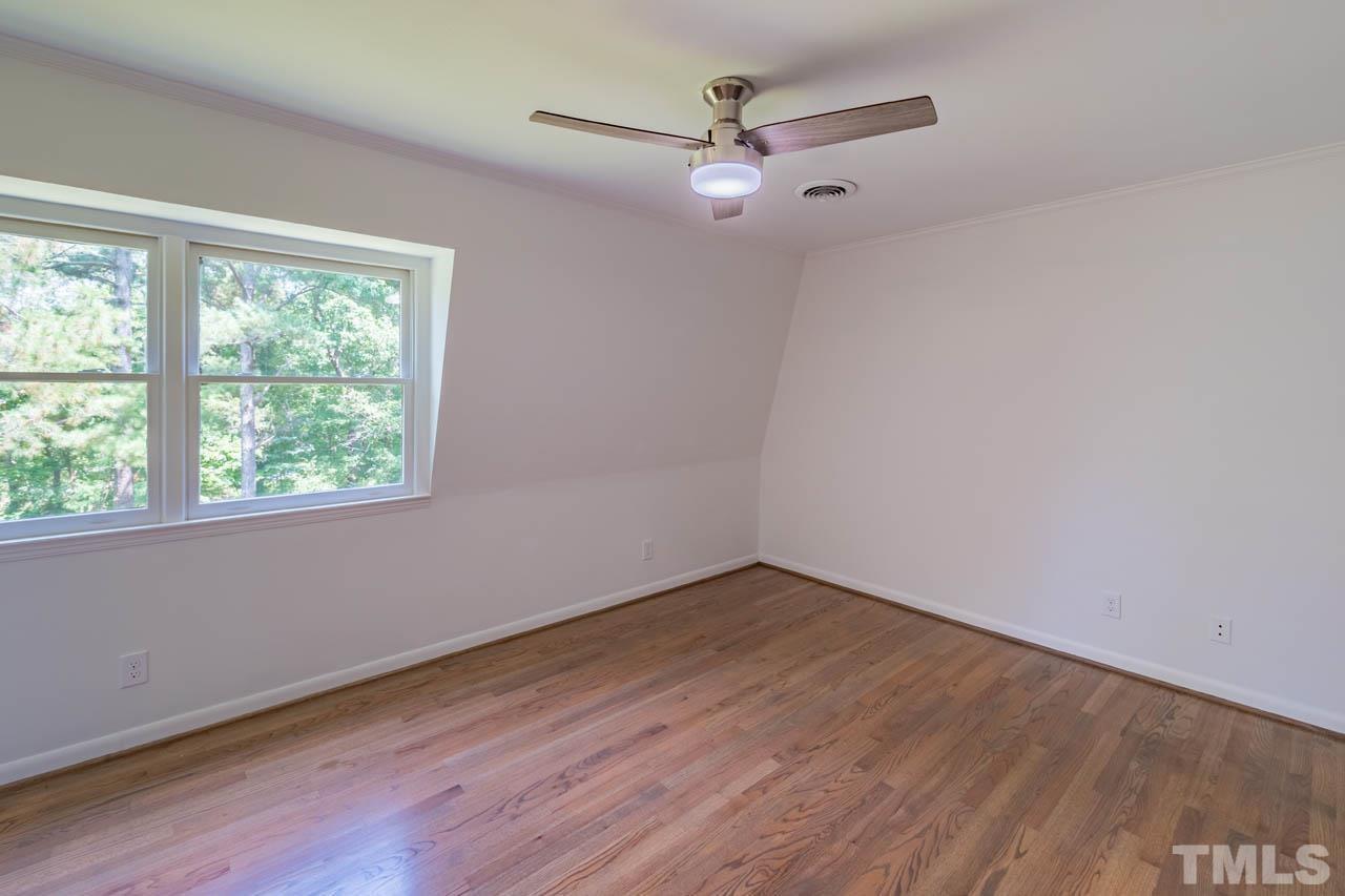 2823 Ridge Road Durham, NC 27705 - Photo 20 of 30 a view of an empty room with wooden floor and a window