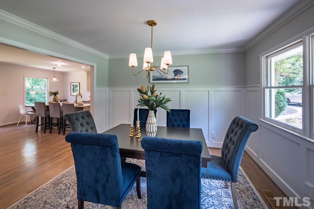 2823 Ridge Road Durham, NC 27705 - Photo 7 of 30 a dining room with wooden floor a chandelier a glass table and chairs