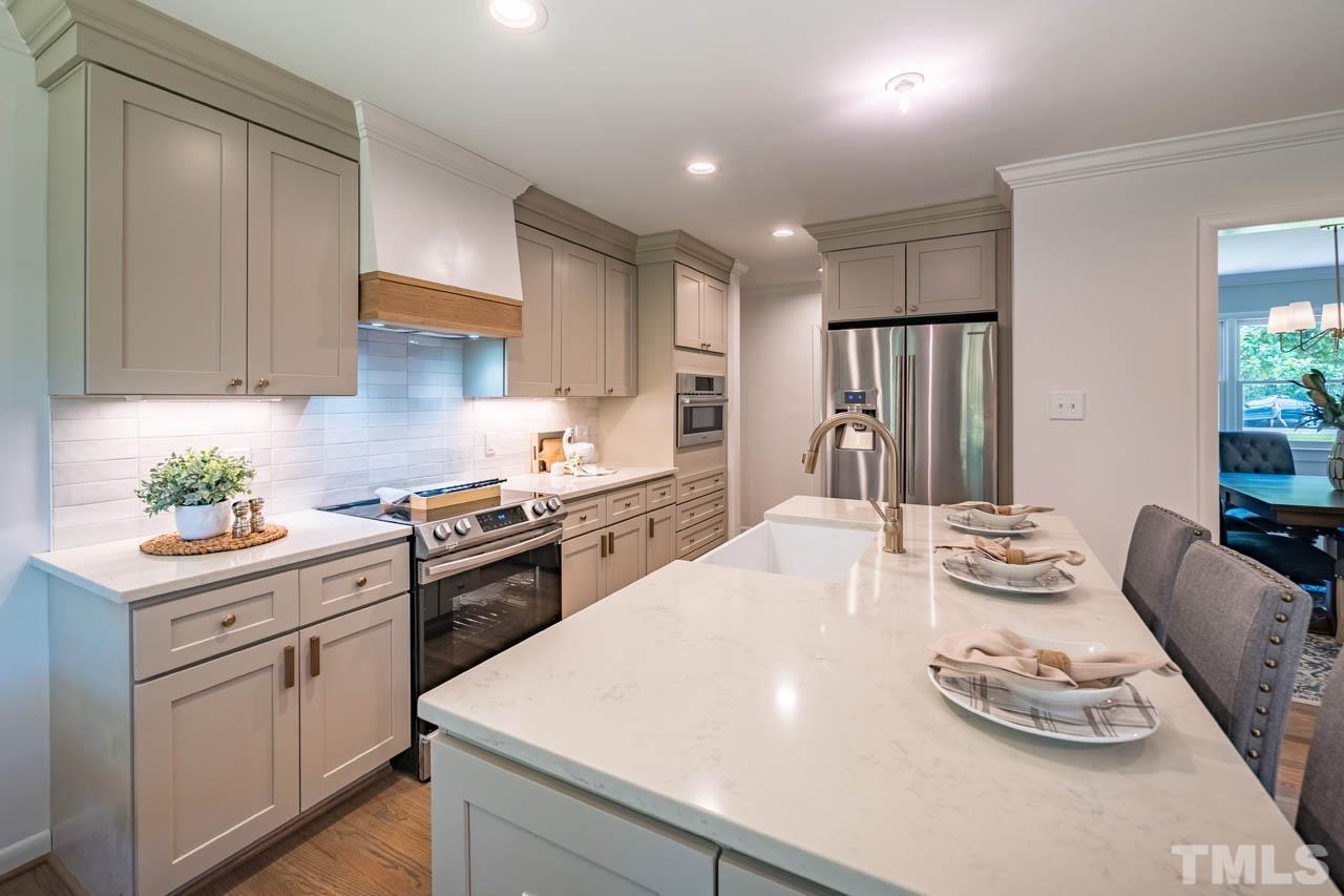 2823 Ridge Road Durham, NC 27705 - Photo 9 of 30 a kitchen with stainless steel appliances kitchen island granite countertop a sink and cabinets