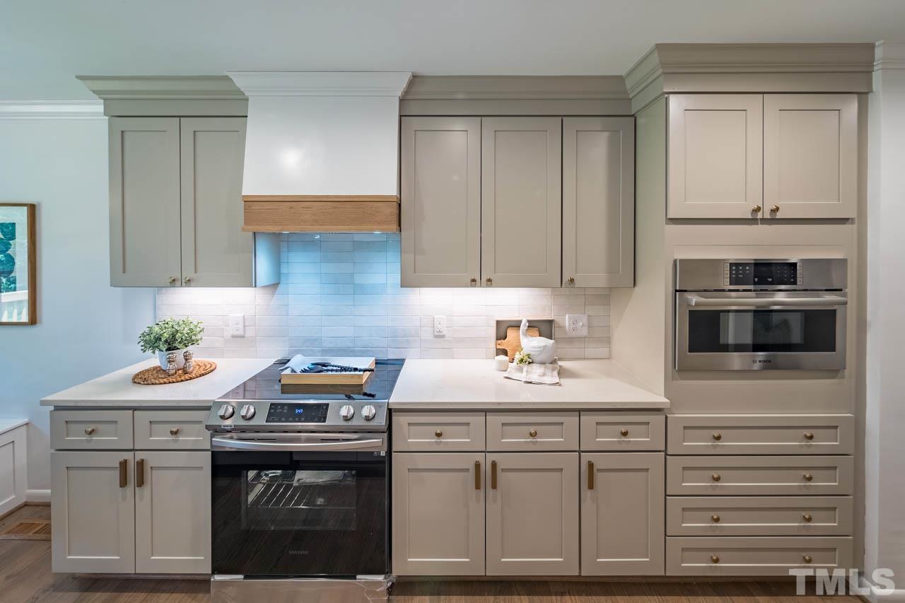 2823 Ridge Road Durham, NC 27705 - Photo 10 of 30 a kitchen with granite countertop white cabinets and white appliances