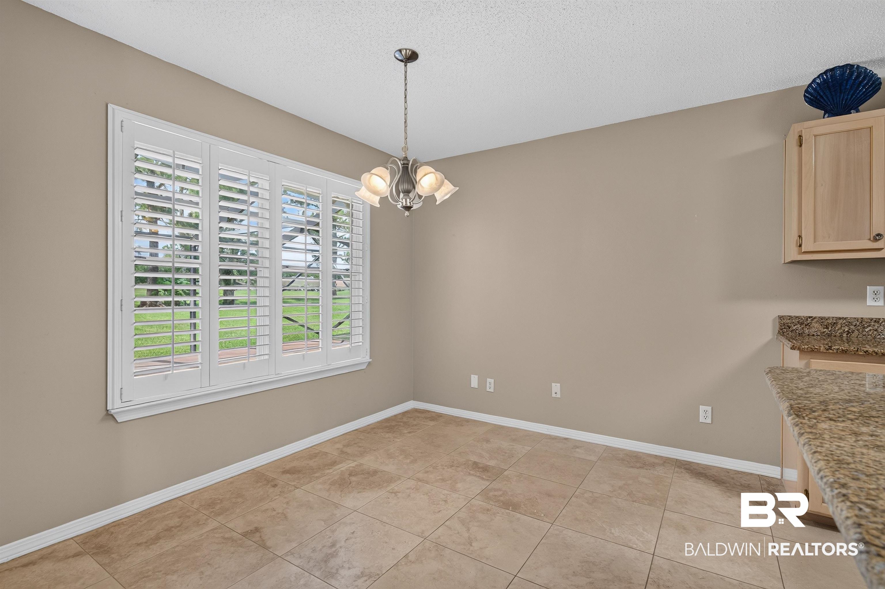 22685 County Road 12 Foley, AL 36535 - Photo 38 of 89 Dining area featuring a chandelier, large window with plantation shutters, tile flooring, and a built-in cabinet with a stone countertop
