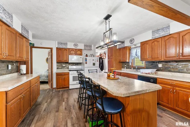 a kitchen with stainless steel appliances granite countertop table chairs sink and cabinets