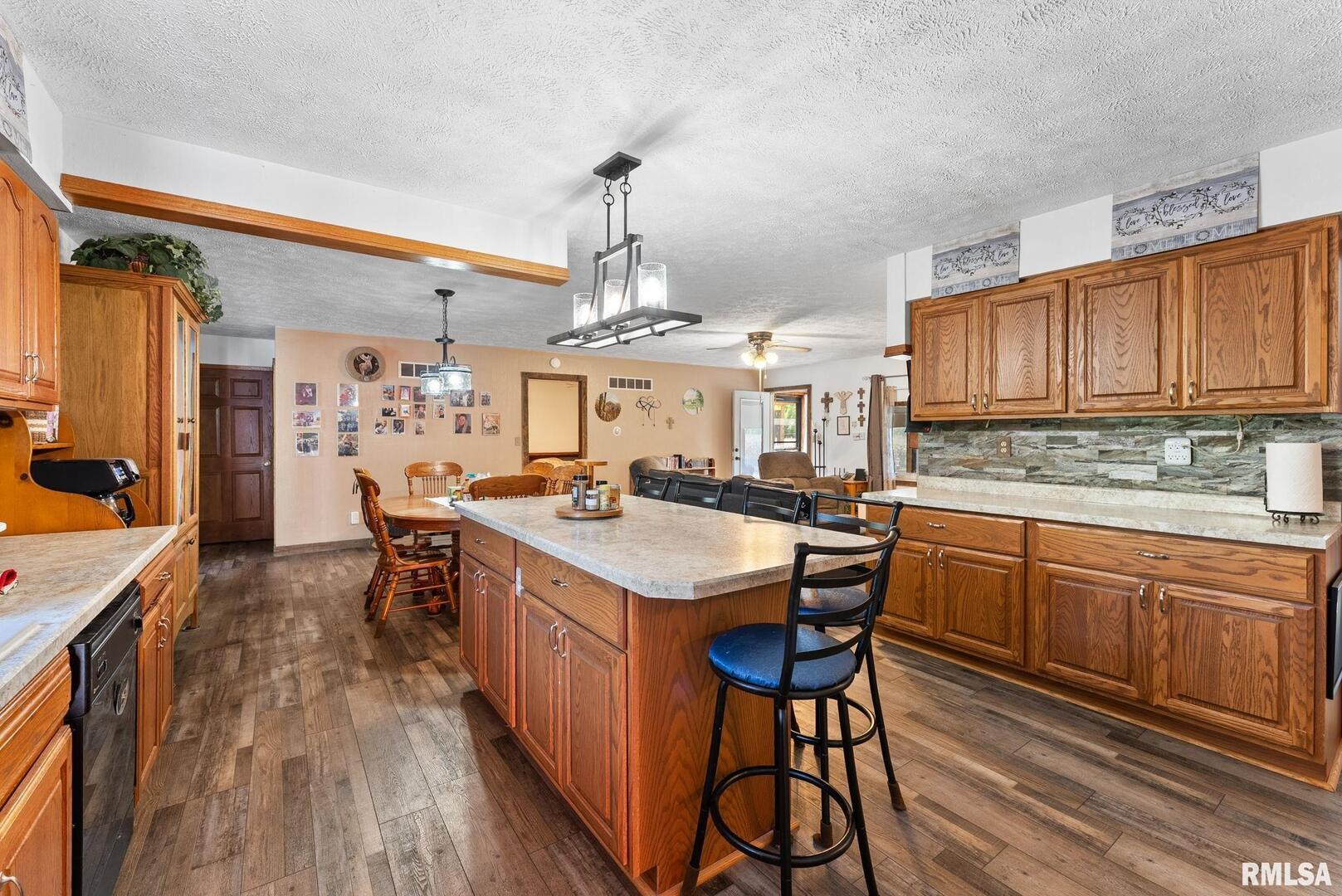 1422 McCloud Road Aledo, IL 61231 - Photo 20 of 44 a kitchen with stainless steel appliances granite countertop a kitchen island a stove a sink dishwasher and cabinets with wooden floor