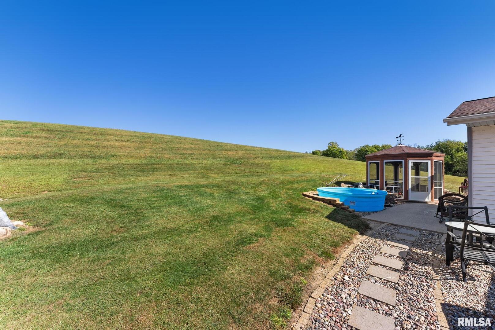 1422 McCloud Road Aledo, IL 61231 - Photo 7 of 44 a view of a patio with lawn chairs under an umbrella
