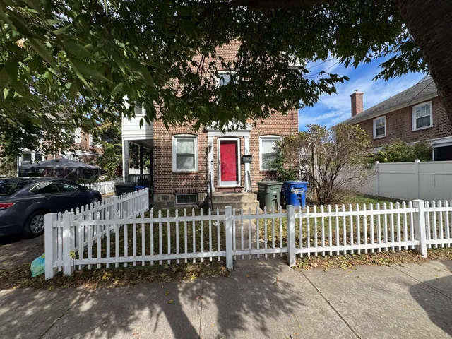 a view of a house with a small yard and wooden fence