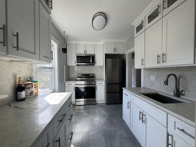 a kitchen with stainless steel appliances a sink cabinets and a refrigerator