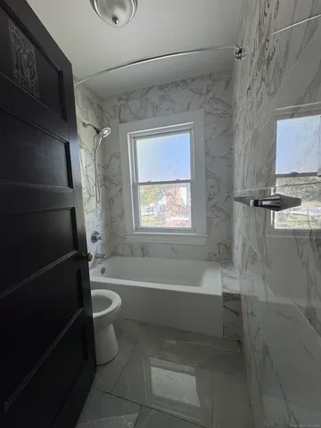 a bathroom with a bathtub a toilet a sink and a shower