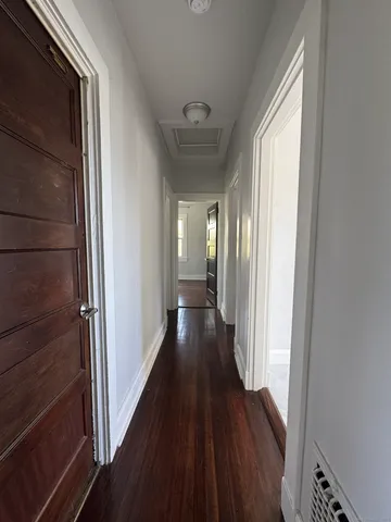 a view of a hallway with wooden floor and staircase